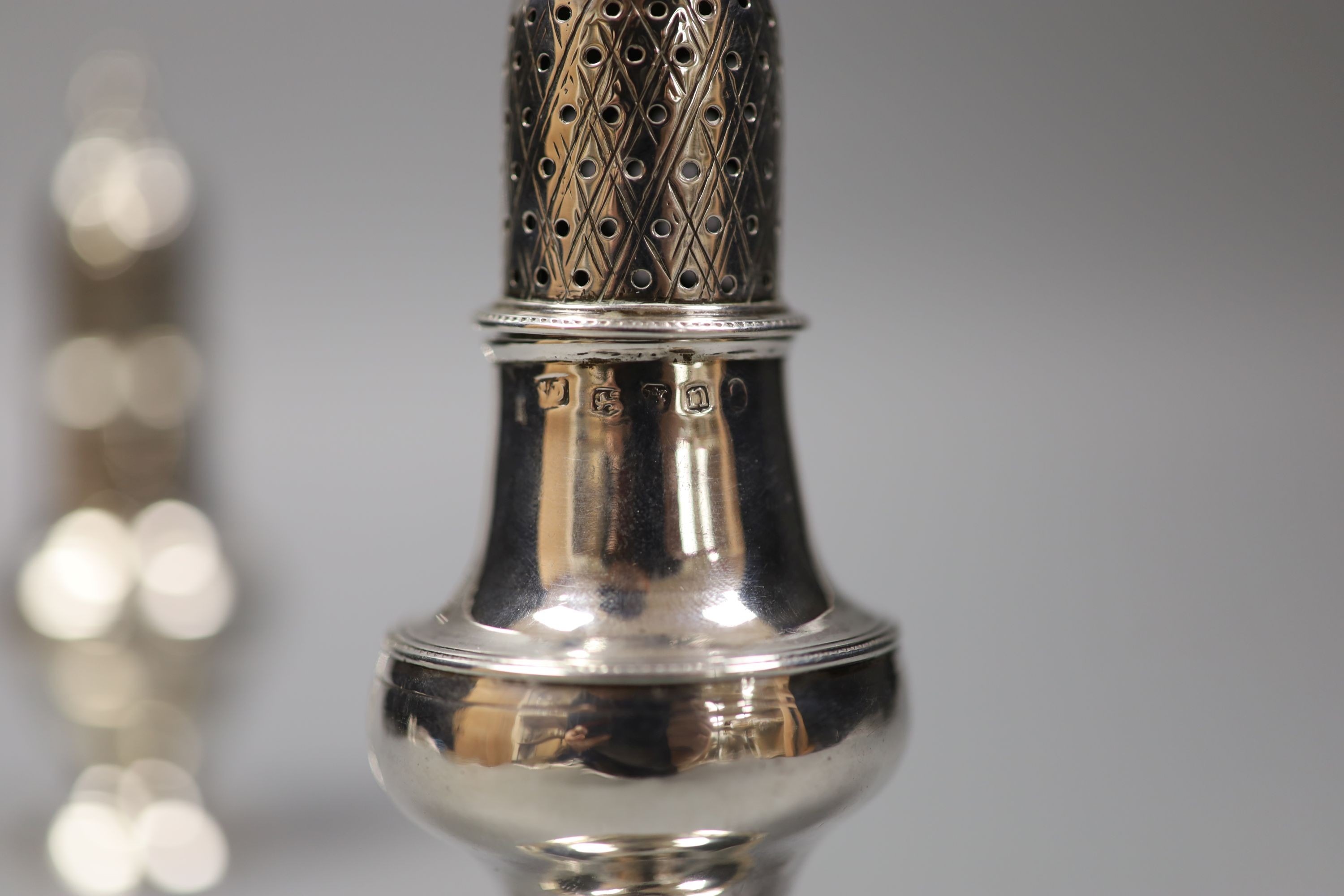 Two Georgian silver pepperettes, London, 1784 and London, 1788, tallest 14.1cm, 149 grams.